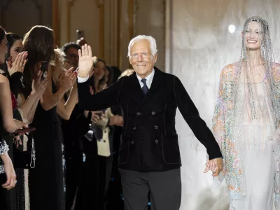 FILE - Giorgio Armani gestures at the end of the Giorgio Armani Prive Haute Couture Spring Summer 2025 collection in Paris, on Jan. 28, 2025. (AP Photo/Lewis Joly, File).