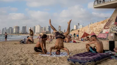 21 June 2025, Israel, Tel-aviv: As tensions between Israel and Iran mount, people seek a brief escape at the beach-soaking up the sun and sea in a quiet moment of normalcy amid growing unease. Photo: Ilia Yefimovich/dpa