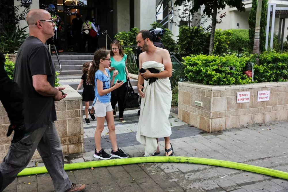 Israeli residents evacuate from an impacted residential site after a missile attack from Iran, amid the Iran-Israel conflict in Tel Aviv, Israel June 22, 2025. REUTERS/Tomer Appelbaum ISRAEL OUT. NO COMMERCIAL OR EDITORIAL SALES IN ISRAEL.