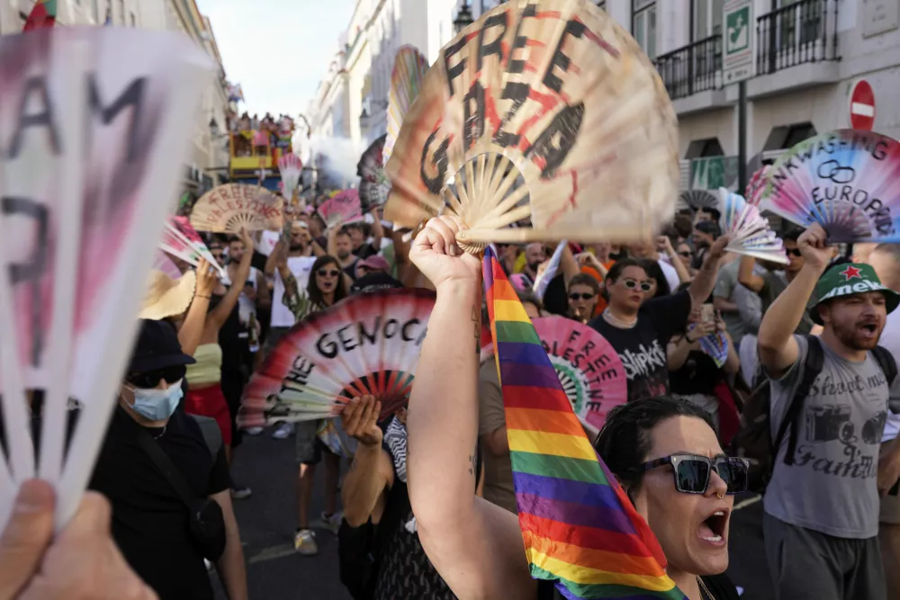 People hold up fans with pro-Palestinian messages and shout slogans during the Europride Parade in Lisbon, Saturday, June 21, 2025. (AP Photo/Armando Franca)