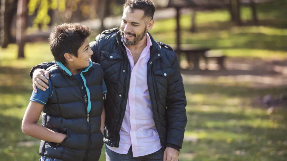 Father and son walking together and having confidential conversations / Foto: Sladic