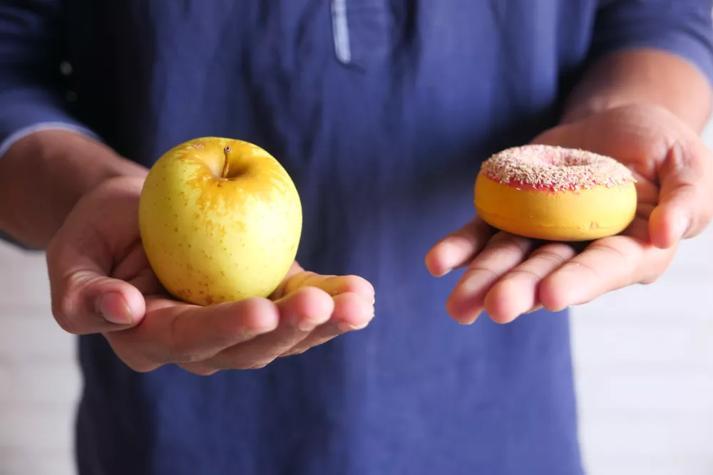 hand holding donuts and apple on hand close up, / Foto: Towfiqu Ahamed