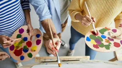 Overview of man with paintbrush teaching his students with color palette how to paint professionally / Foto: Seventyfour