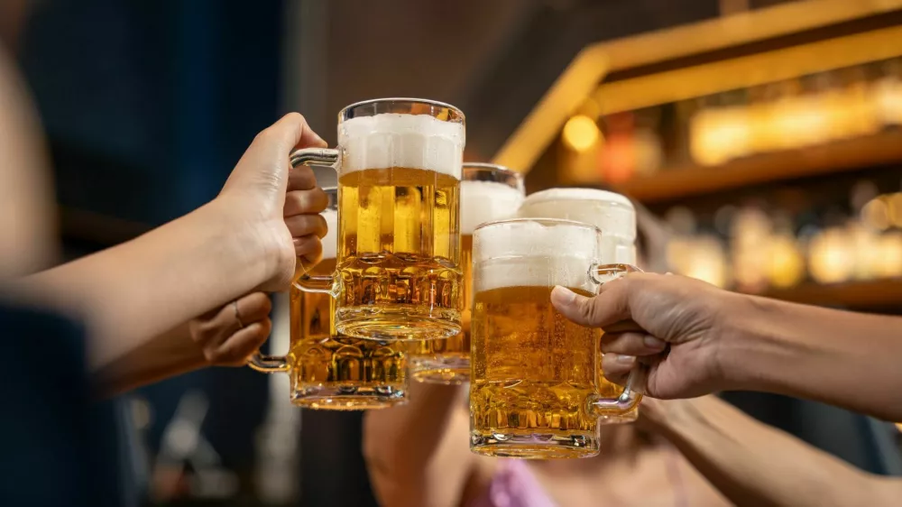 Close-up Group of People Holding Beer and Cheer in Restaurant. They Enjoying with Night Party Together. Party, Lifestyle, Happiness, Cheerful and Celebration Concept. / Foto: Bavorndej
