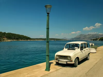 An old car parked near a street lamp and the sea on the island of Brac in Croatia / Foto: Tatiana Zayats