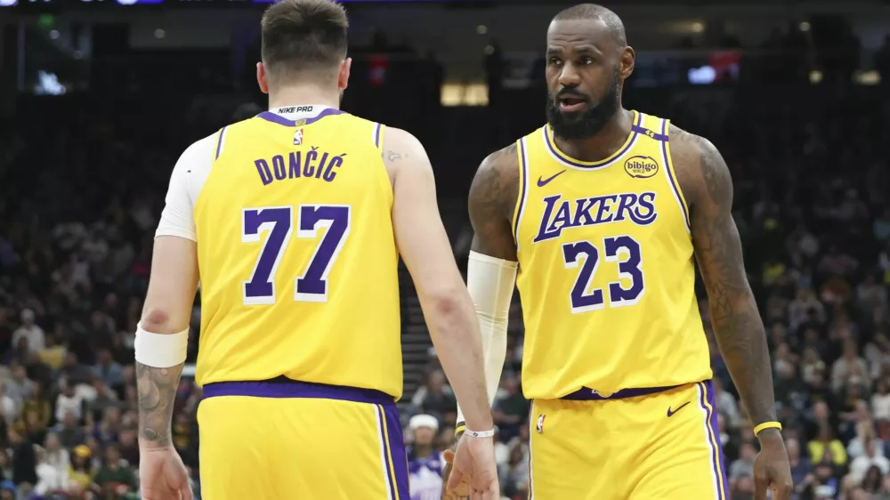 Los Angeles Lakers forward LeBron James (23) slaps hands with guard Luka Doncic (77) during the second half of an NBA basketball game against the Utah Jazz, Wednesday, Feb. 12, 2025, in Salt Lake City. (AP Photo/Rob Gray)