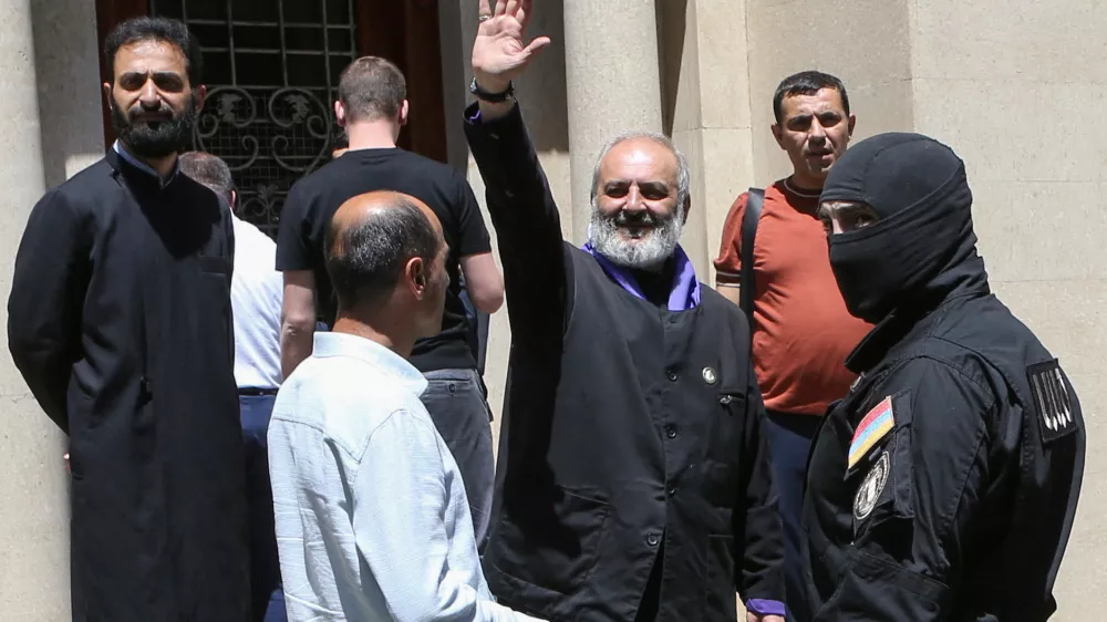 Archbishop of the Armenian Apostolic Church Bagrat Galstanyan, who is charged with attempting to overthrow the government and destabilizing the state, waves to supporters as Armenia's National Security officers arrive to arrest him in Yerevan, Armenia, June 25, 2025. Melik Baghdasaryan/Photolure via REUTERS ATTENTION EDITORS - THIS IMAGE HAS BEEN SUPPLIED BY A THIRD PARTY.