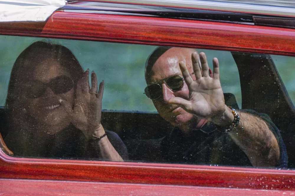 Amazon multi-billionaire founder Jeff Bezos, right, and Lauren Sanchez arrive by boat at an hotel in Venice, Italy, on Wednesday, June 25, 2025, ahead of festivities in the lagoon city reportedly linked to their wedding. (AP Photo/Luca Bruno))