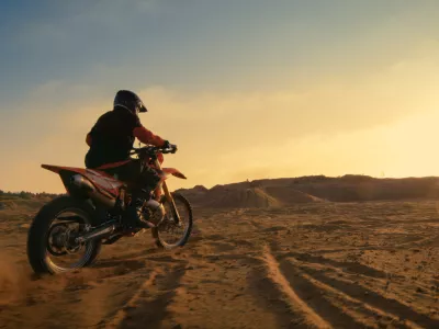 Shot of the Professional Motocross Driver Riding on His FMX Motorcycle on the Extreme Off-Road Terrain Track. / Foto: Gorodenkoff