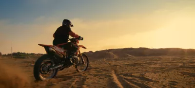 Shot of the Professional Motocross Driver Riding on His FMX Motorcycle on the Extreme Off-Road Terrain Track. / Foto: Gorodenkoff