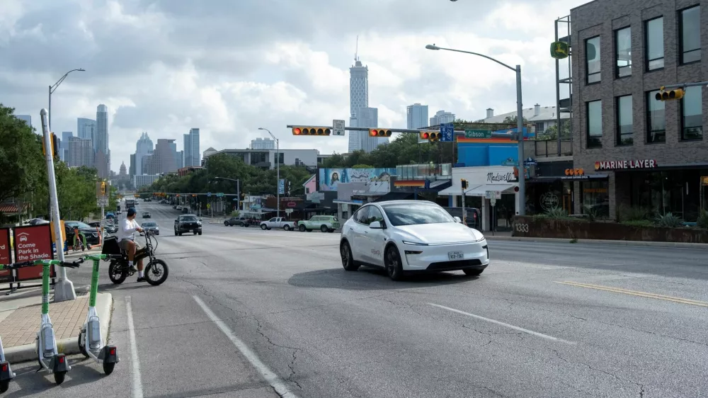 FILE PHOTO: A Tesla robotaxi drives on the street along South Congress Avenue in Austin, Texas, U.S., June 22, 2025. REUTERS/Joel Angel Juarez/File Photo