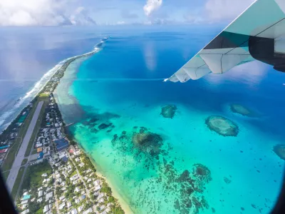 Tuvalu under the wing of an airplane. Aerial view of Funafuti atoll and the airstrip of International airport in Vaiaku. Fongafale motu. Island nation in Polynesia, South Pacific Ocean, Oceania.