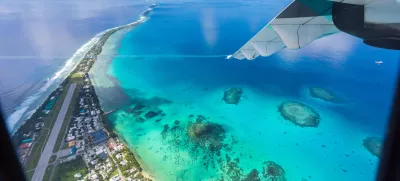 Tuvalu under the wing of an airplane. Aerial view of Funafuti atoll and the airstrip of International airport in Vaiaku. Fongafale motu. Island nation in Polynesia, South Pacific Ocean, Oceania.