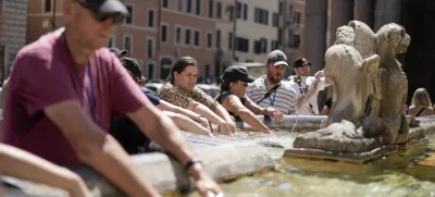 People cool off at a fountain in front of the Pantheon, in Rome, Saturday, Aug. 19, 2023. Italy is facing a heat wave with temperatures in the capital as high as 37 Celsius (98 Farenheit). (AP Photo/Andrew Medichini)