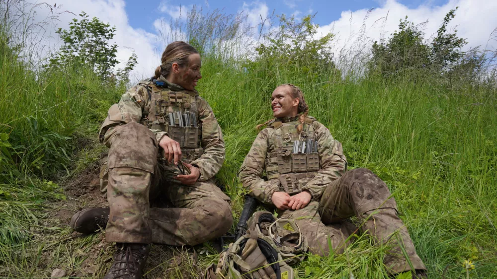 20-year-old conscript Katrine, right, speaks with another female conscript during final exercises at a training area close to Royal Danish Army's barracks in Hovelte, 25 kilometres north of Copenhagen, Denmark, Wednesday, June 11, 2025. (AP Photo/James Brooks)