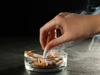 Woman extinguishing cigarette in glass ashtray / Foto: Liudmila Chernetska