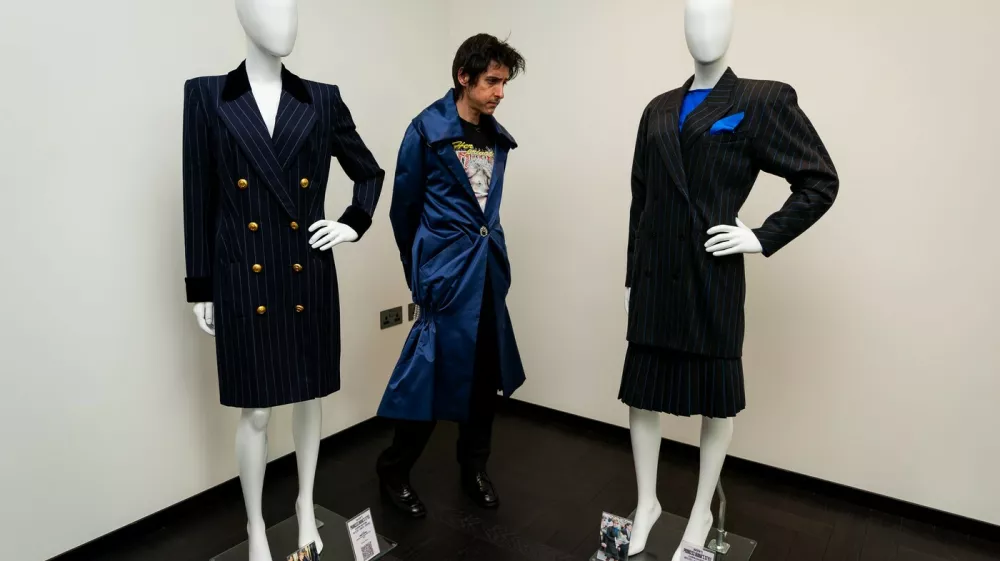 A person views a Princess Diana 1995 New York Catherine Walker Coat Dress estimated between $30,000 - $50,000 and a Princess Diana Three Piece Escada Suit estimated between $30,000 - $50,000 on display at the preview of Princess Diana's Style & Royal Collection, the largest collection of Diana, Princess of Wales' fashion to appear at auction. Over 200 items of Princess Diana's wardrobe feature alongside pieces owned by the Duke and Duchess of Windsor, Queen Elizabeth II and the Queen Mother in the private exhibition at the Peninsula London, before heading to the Peninsula Beverly Hills where the items will be sold by Julien's Auctions on June 26. Picture date: Tuesday June 3, 2025.,Image: 1006694435, License: Rights-managed, Restrictions:, Model Release: no