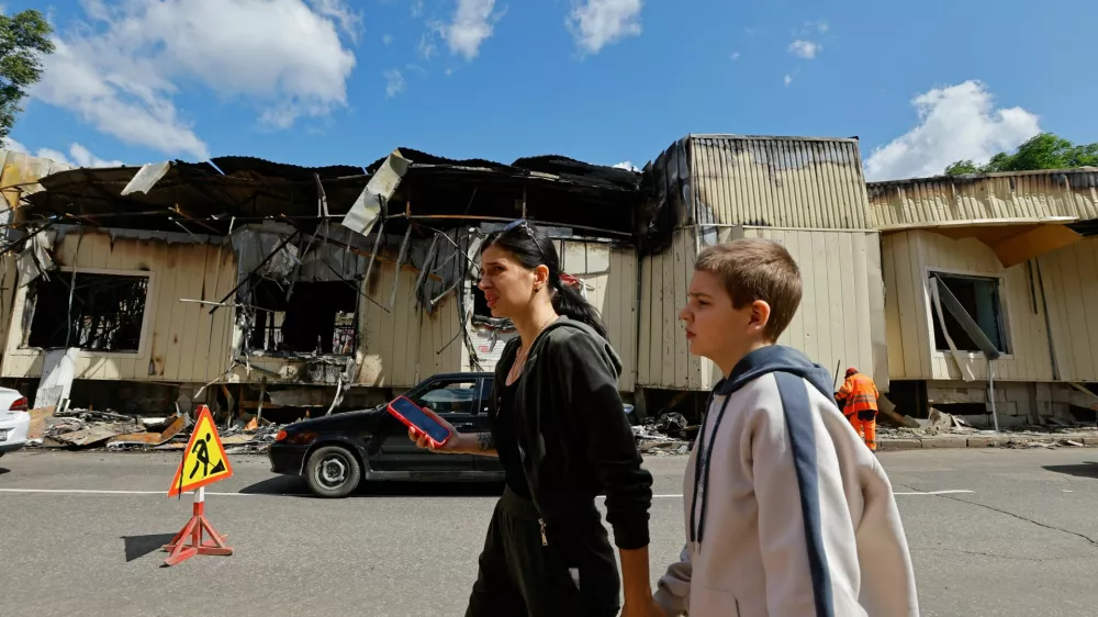 People walk past destroyed shops at the market, which was hit on Monday by shelling that local Russian-installed authorities called a Ukrainian military strike, in the course of Russia-Ukraine conflict in Donetsk, a Russian-controlled city of Ukraine, July 1, 2025. REUTERS/Alexander Ermochenko