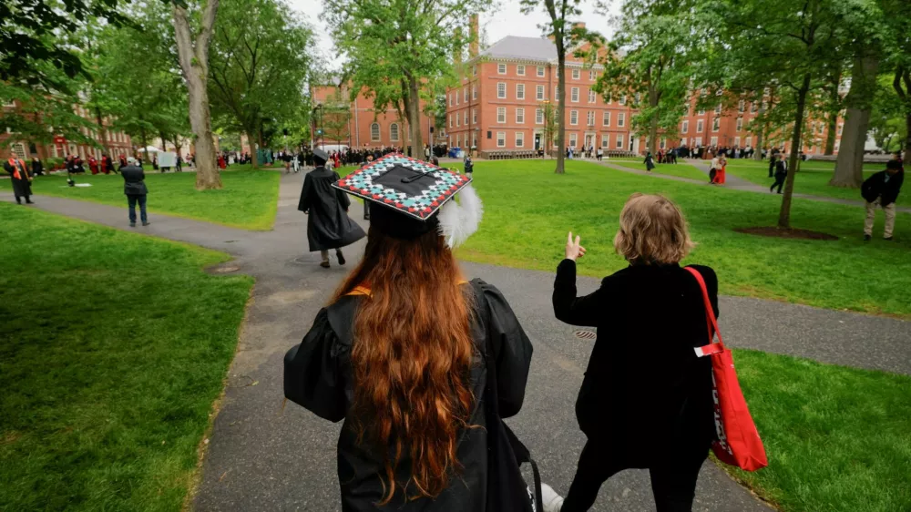 FILE PHOTO: People walk to attend the 374th Commencement exercises at Harvard University in Cambridge, Massachusetts, U.S., May 29, 2025. REUTERS/Brian Snyder/File Photo
