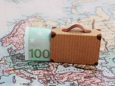 Europe city trip travel budget concept with 100 euro note and suitcase on map / Foto: Misstuni