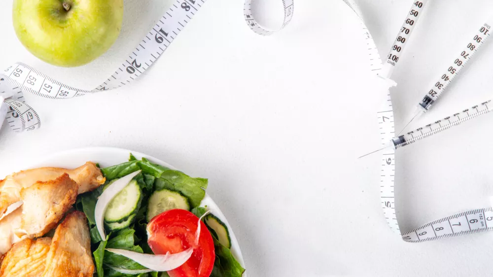 Weight loss injection. Insulin resistance, diabetes, slimming healthy eating. Injections with hormones doses syringes, with measuring tape, dumbbells, balanced plate salad and meat and apple / Foto: Rimma_bondarenko