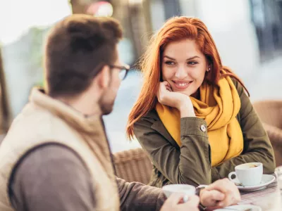 Attractive young couple in love sitting at the cafe table outdoors, drinking coffee / Foto: Jovanmandic