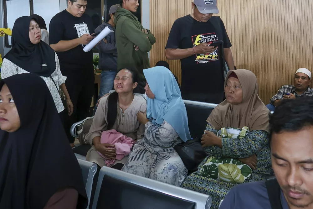 A passenger's relative weeps after a ferry carrying dozens of passengers sank near the resort island of Bali, at Ketapang Port in Bayuwangi, East Java, Indonesia, Thursday, July 3, 2025. (AP Photo/Andur)