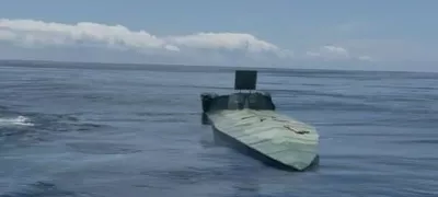 SANTA MARTA, COLOMBIA - JULY 2: (-----EDITORIAL USE ONLY MANDATORY CREDIT - 'COLOMBIAN NAVY PRESS OFFICE / HANDOUT' - NO MARKETING NO ADVERTISING CAMPAIGNS - DISTRIBUTED AS A SERVICE TO CLIENTS-----) A low-profile unmanned semi-submersible vessel sits between two Colombian Navy boats off the coast of Tayrona Park near Santa Marta, Colombia, on July 2, 2025. The Orion Multinational Strategy, led by the Colombian Navy, warns of a growing threat: the use of autonomous technologies by drug trafficking networks. In early 2025, Colombia seized its first autonomous semi-submersible in the Caribbean, a case that reflects a shift toward more sophisticated, radar-evading systems. Colombian Navy Press Office / Handout / AnadoluNo Use USA No use UK No use Canada No use France No use Japan No use Italy No use Australia No use Spain No use Belgium No use Korea No use South Africa No use Hong Kong No use New Zealand No use Turkey