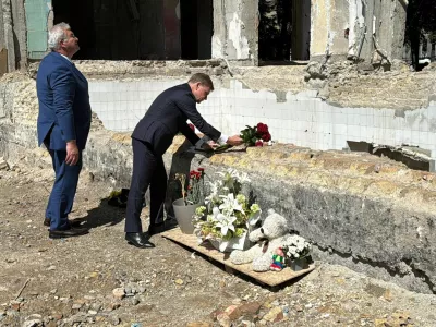 FILED - 30 June 2025, Ukraine, Kiev: German Foreign Minister Johann Wadephul and Ukrainian Foreign Minister Andrij Sybiha lay roses at the site of a residential building destroyed in a rocket attack on June 17, which killed 28 people and injured more than 130. A German embassy employee was among those affected, with her apartment damaged by the blast wave. Photo: Jörg Blank/dpa