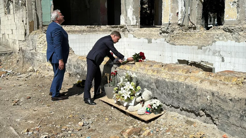 FILED - 30 June 2025, Ukraine, Kiev: German Foreign Minister Johann Wadephul and Ukrainian Foreign Minister Andrij Sybiha lay roses at the site of a residential building destroyed in a rocket attack on June 17, which killed 28 people and injured more than 130. A German embassy employee was among those affected, with her apartment damaged by the blast wave. Photo: Jörg Blank/dpa
