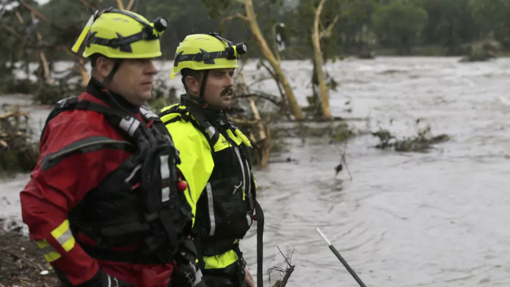 CORRECTS DAY - Kerrville Fire Department first responders scan the banks of the Guadalupe River for individuals swept away by flooding in Ingram, Texas, Friday, July 4, 2025. (Michel Fortier/The San Antonio Express-News via AP)