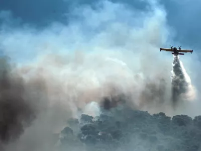 04 July 2025, Greece, Athens: A firefighting helicopter flies over a wildfire burning in Aghios Dimitrios east of Athens. Photo: Aristidis Vafeiadakis/ZUMA Press Wire/dpa