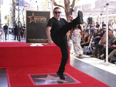 Comedian Ricky Gervais celebrates with a kick at a ceremony honoring him with a star on the Hollywood Walk of Fame on Friday, May 30, 2025, in Los Angeles. (AP Photo/Chris Pizzello)