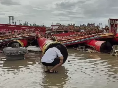 In this image made from a video provided by TVBS, a resident checks the collapsed temple structures submerged in floodwaters Monday, July 7, 2025, after the Typhoon Danas landed in Tainan, Taiwan. (TVBS via AP)