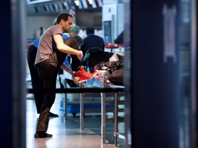 FILE PHOTO: A traveler removes his shoes before going through a security check point at John F. Kennedy Airport in New York, February, 29, 2012.  REUTERS/Andrew Burton/File Photo