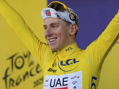 Slovenia's Tadej Pogacar wearing the overall leader's yellow jersey celebrates on the podium after the fifth stage of the Tour de France cycling race, an indivdual time-trial over 33 kilometers (20.5 miles) with start and finish in Caen, France, Wednesday, July 9, 2025. (AP Photo/Mosa'ab Elshamy)