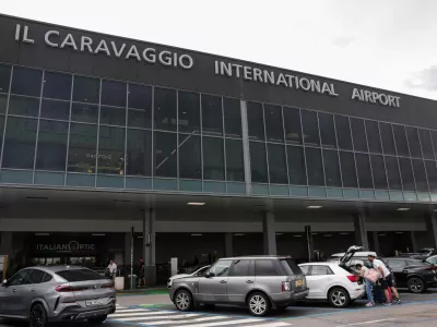 People stand in front of Milan Bergamo Airport (Il Caravaggio International Airport), on the day of the death of a person on a runway during take-off preparations, in Orio al Serio, near Bergamo, Italy, July 8, 2025. REUTERS/Claudia Greco