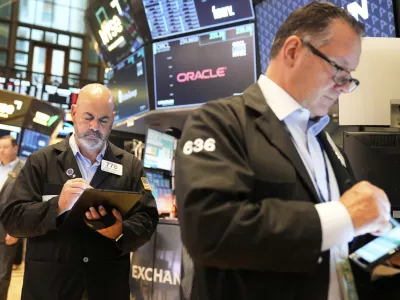 Federico DeMarco, left, and Ed Curran work on the floor at the New York Stock Exchange in New York, Wednesday, July 16, 2025. (AP Photo/Seth Wenig)