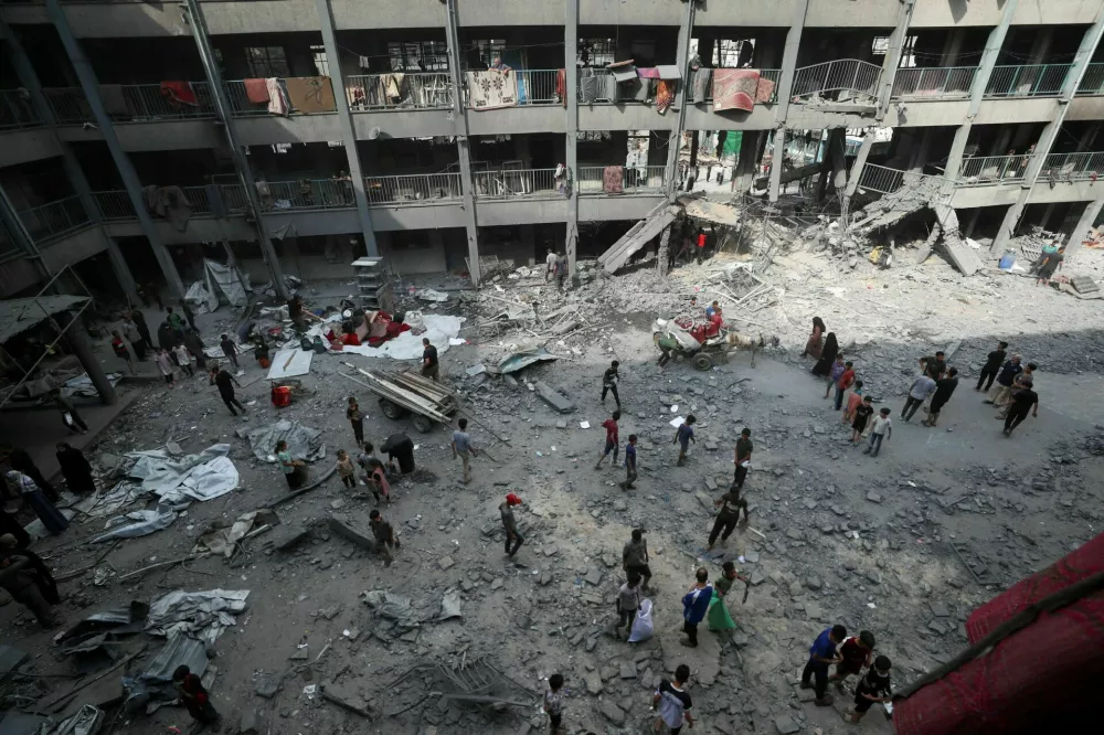 Palestinians inspect the damage at an UNRWA school sheltering displaced people that was hit in an Israeli air strike on Sunday, in Gaza City, June 30, 2025. REUTERS/Mahmoud Issa  TPX IMAGES OF THE DAY