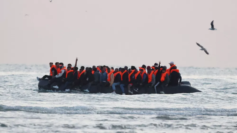 Migrants sit on an inflatable dinghy as it sails along the coastline near Gravelines, France, July 10, 2025. REUTERS/Phil Noble   TPX IMAGES OF THE DAY