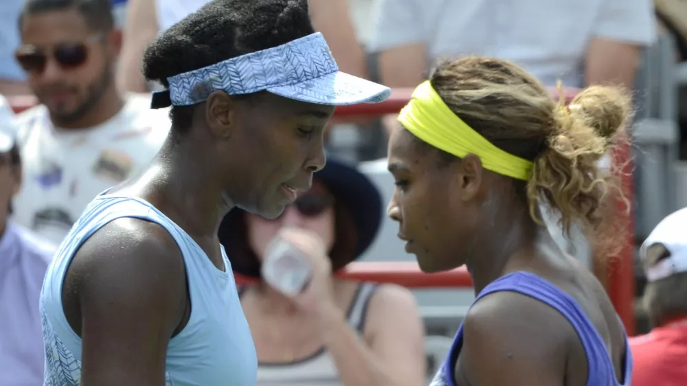 ﻿Venus Williams, left, and her sister Serena walk to their seats between games during semifinal play at the Rogers Cup tennis tournament, Saturday, Aug. 9, 2014 in Montreal. (AP Photo/The Canadian Press, Paul Chiasson)