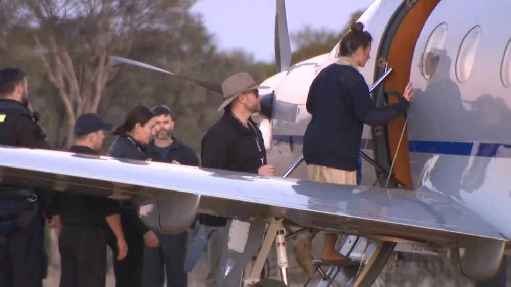 SCREENSHOT - 11 July 2025, Australia, ---: A screenshot from an ABC television video shows Carolina Wilga (R) boarding a plane. A German backpacker who had been missing for 12 days in remote bushland has been found alive by emergency services. Photo: -/ABC via AAP/dpa - ACHTUNG: Nur zur redaktionellen Verwendung und nur mit vollständiger Nennung des vorstehenden Credits