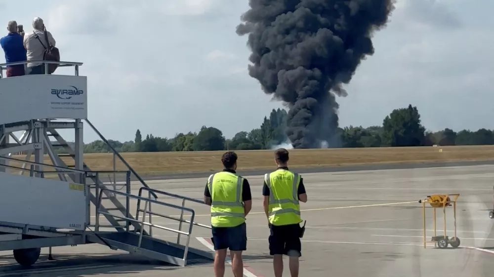 A plume of black smoke rises from an area near the runway after a small plane crash, as seen from inside a building at London Southend Airport, in Southend, Britain, July 13, 2025, in this screen grab obtained from a social media video. @agussromagnoli via X/via REUTERS THIS IMAGE HAS BEEN SUPPLIED BY A THIRD PARTY. MANDATORY CREDIT.