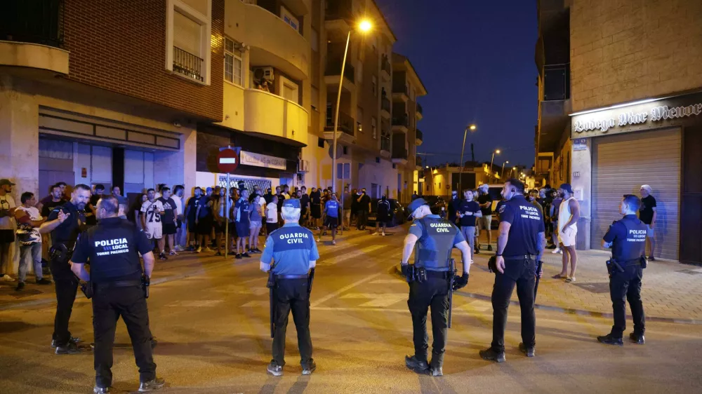 Local police officers and Spanish civil guard agents take positions during the disturbances in Torre Pacheco, eastern Spain, Friday, July 12, 2025. (Martín C./Europa Press via AP)