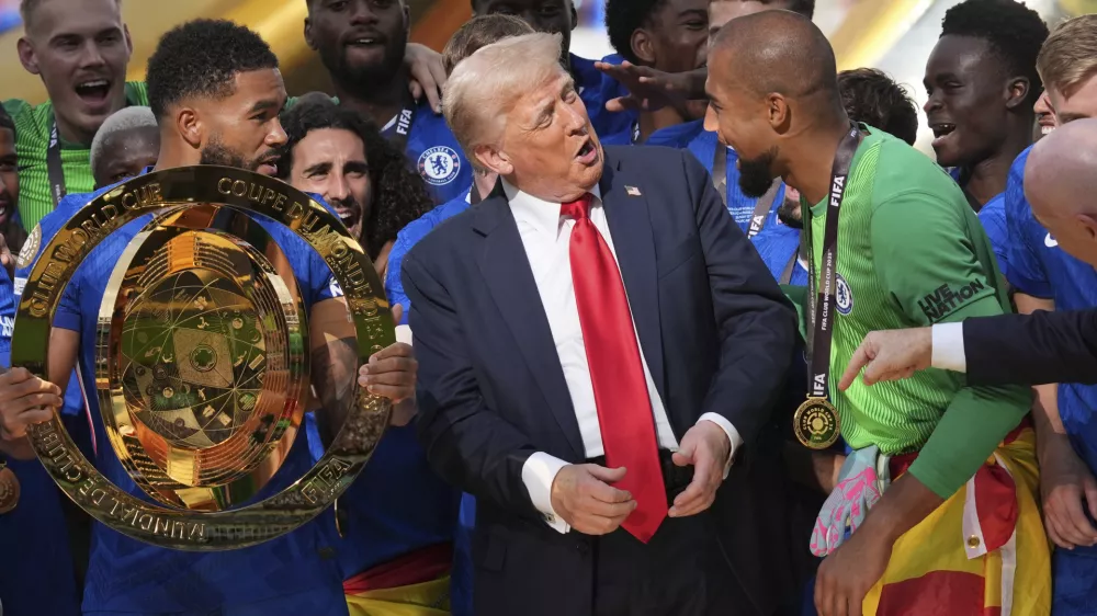 President Donald Trump, center, speaks with Chelsea's goalkeeper Robert Sanchez, right, as Chelsea's Reece James (24) holds the championship trophy following the Club World Cup final soccer match between Chelsea and PSG at MetLife Stadium in East Rutherford, N.J., Sunday, July 13, 2025. (AP Photo/Jacquelyn Martin)