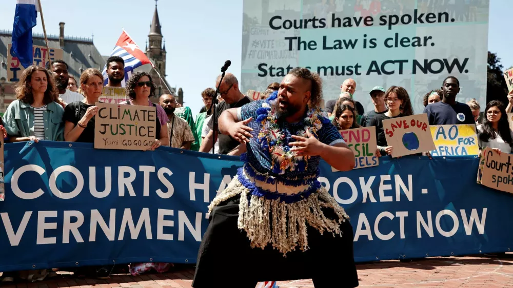 Climate activists and campaigners demonstrate outside the International Court of Justice (ICJ) ahead of the reading of an advisory opinion that is likely to determine the course of future climate action across the world, The Hague, Netherlands, July 23, 2025. REUTERS/Marta Fiorin