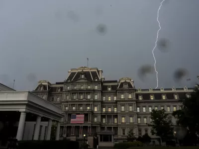 A bolt of lightning comes down behind the Eisenhower Executive Office Building on the White House complex, Monday, July 14, 2025, in Washington. (AP Photo/Alex Brandon)
