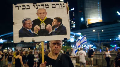 A protestor hold up a sign with Bezalel Smotrich and Itamar Ben Gvir strangle PM Benjamin Netanyahu with a yellow ribbon that reads: ?Senior political figure?. Thousands of Israelis demonstrated with the hostage?s families against Prime Minister Benjamin Netanyahu, demanding an immediate hostage deal and ceasefire - as Israel awaits for the Iranian and Hezbollah attack. Tel Aviv, Israel. August 10th 2024. (Matan Golan / Sipa USA).