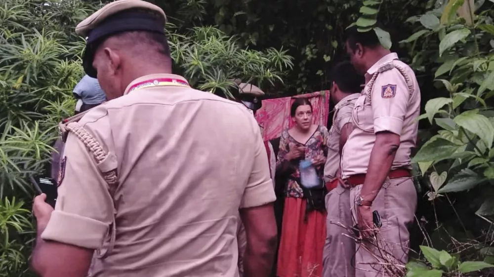 Indian policemen rescue Nina Kutina, 40, a Russian woman, from a cave in forest area of Ramtirtha hills in southern Indian state of Karnataka, Wednesday, July 9, 2025. (Uttara Kannada District Police via AP)