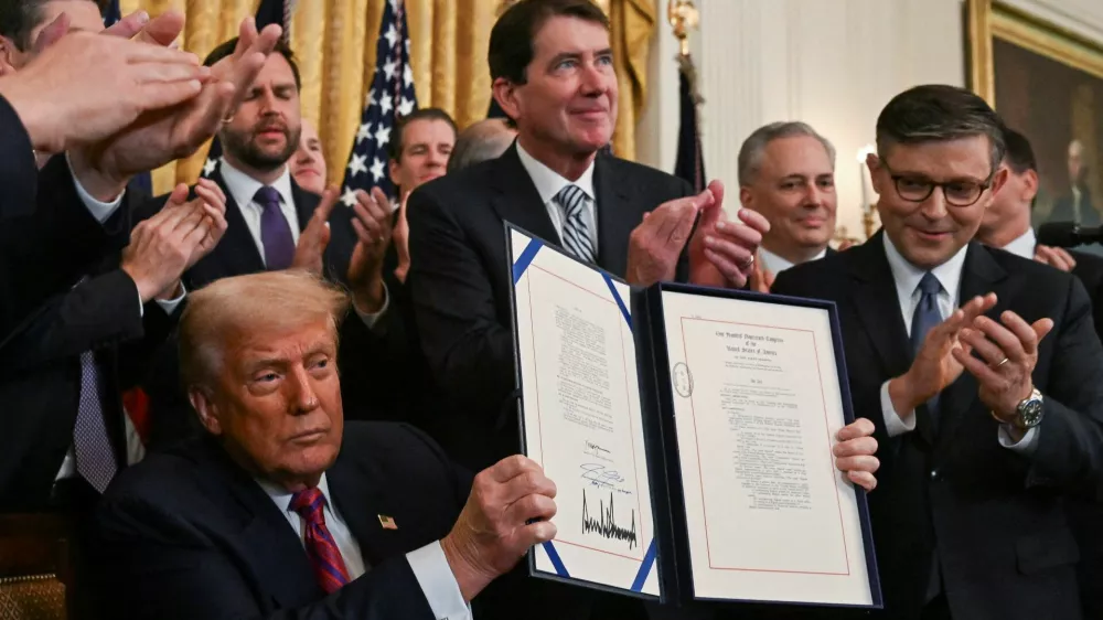 U.S. President Donald Trump holds the signed "Genius Act", which will develop regulatory framework for stablecoin cryptocurrencies and expand oversight of the industry, at the White House in Washington, D.C., U.S., July 18, 2025. REUTERS/Annabelle Gordon